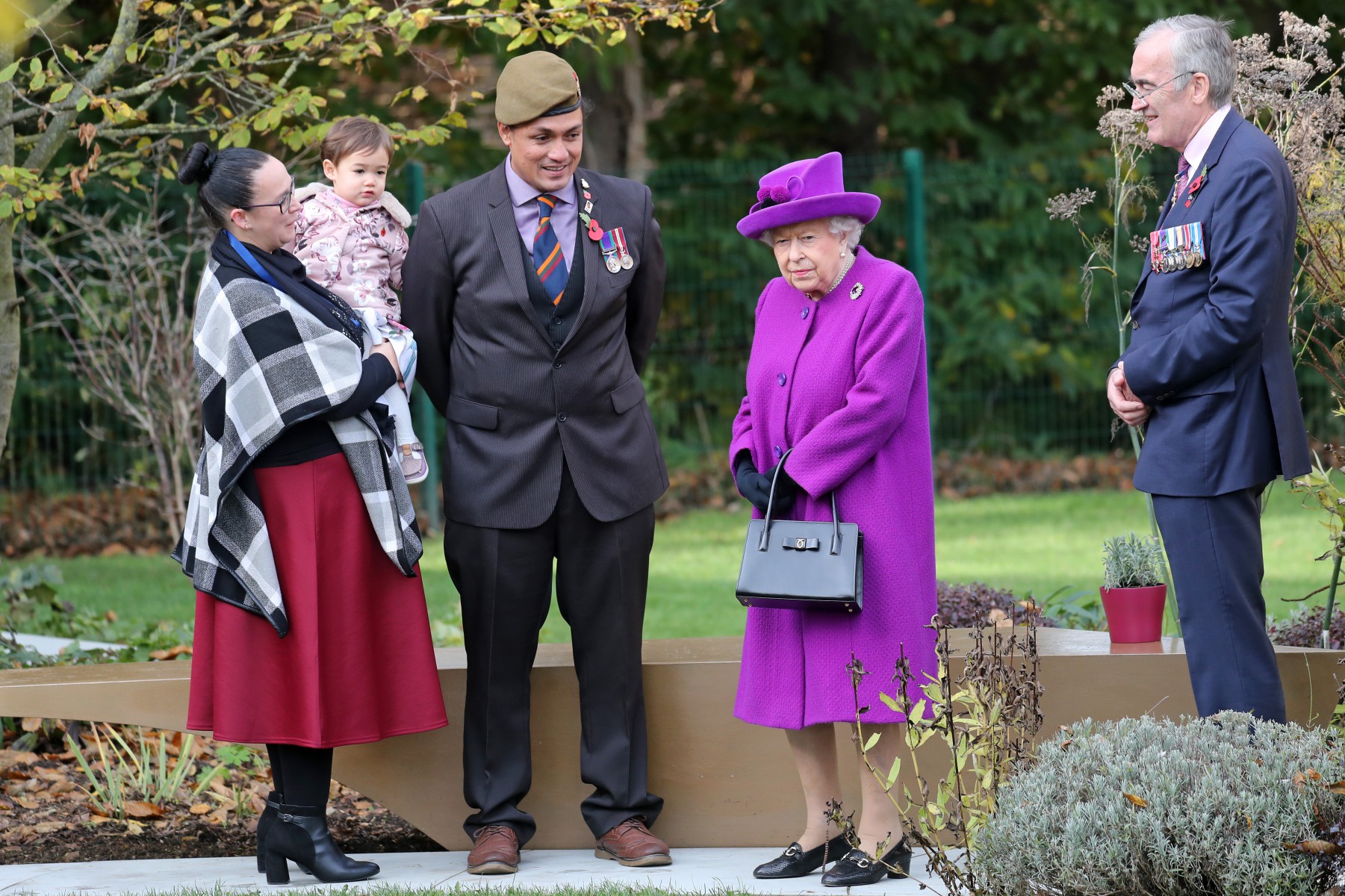 The Queen chats with veteran John Ahben and his family during a visit to the Royal British Legion Industries village