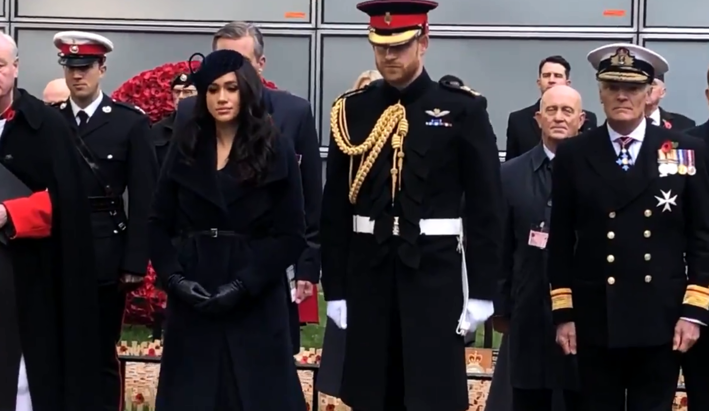 Meghan and Harry stand to attention as they place crosses
