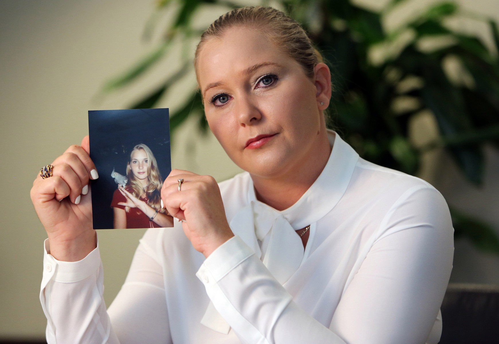 Virginia Roberts holds a photo of herself at age 16 a year after he claim she was first abused by Epstein