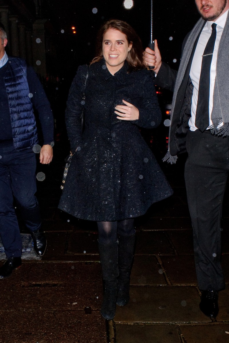 Princess Eugenie clutches a dark blue coat around her as she arrives