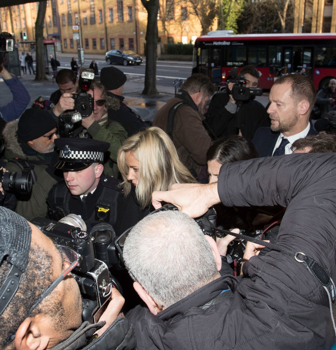 Police push their way through photographers as Flack walked into court