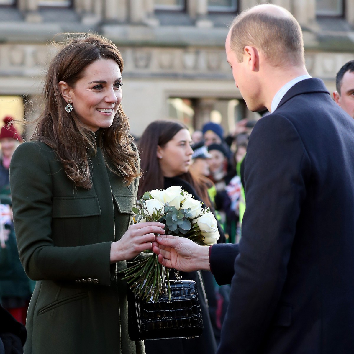 Prince William handing Kate Middleton a white rose