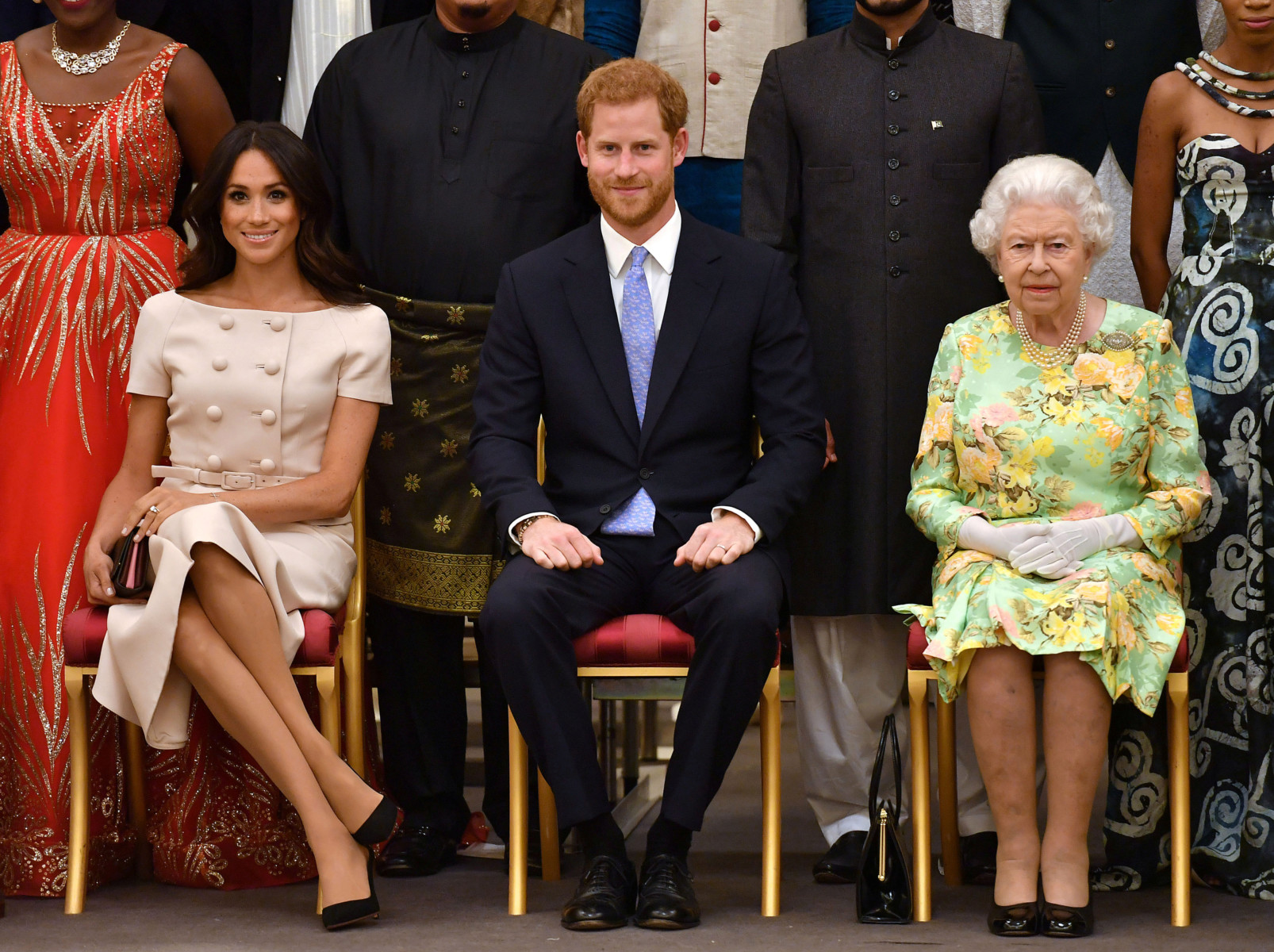 : Britain's Queen Elizabeth, Prince Harry and Meghan, the Duchess of Sussex pose for a picture with some of Queen's Young Leaders at a Buckingham Palace reception following the final Queen's Young Leaders Awards Ceremony, in London