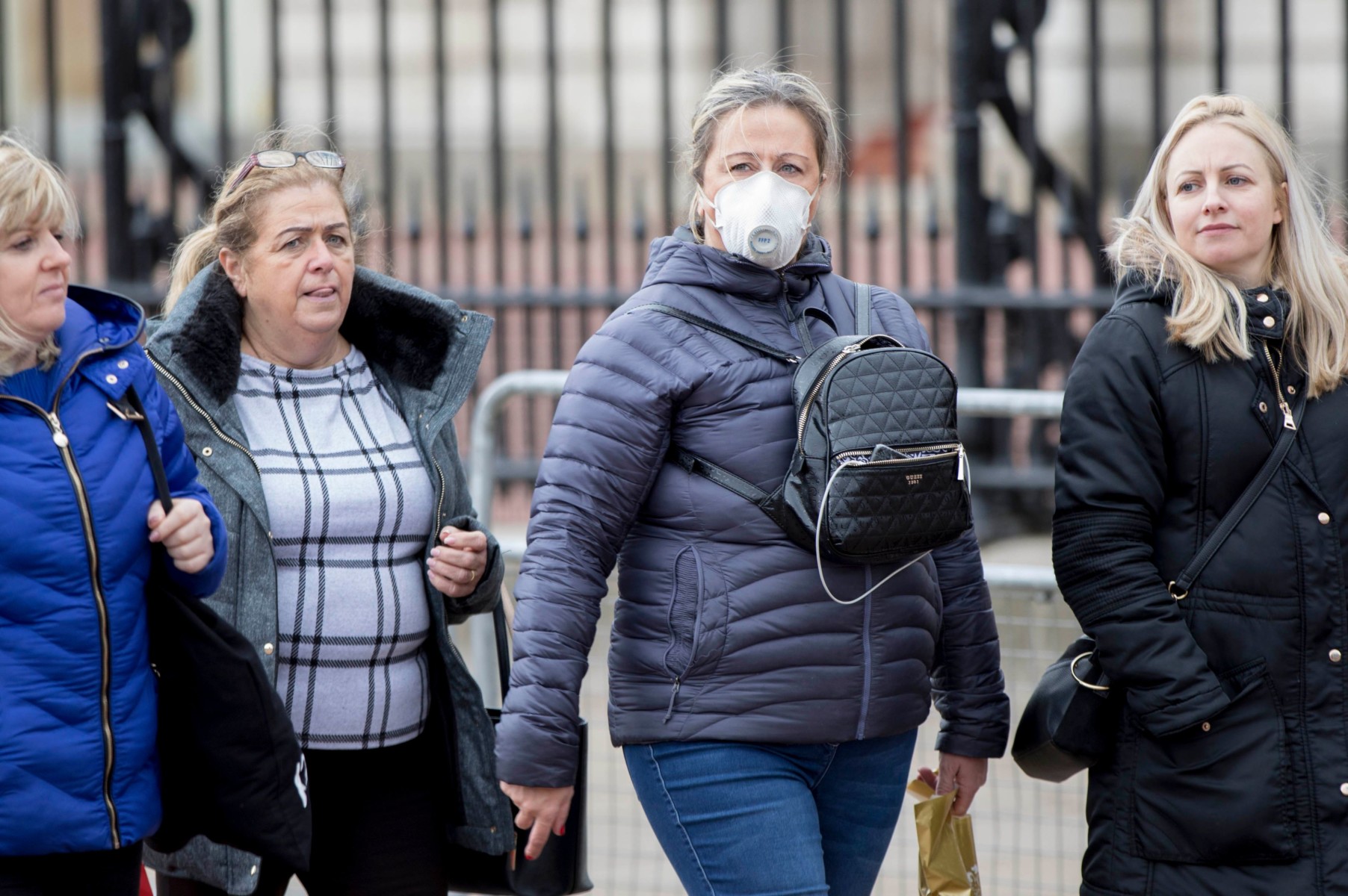 A woman wearing a protective face mask walks past Buckingham Palace, London, as Health Secretary Matt Hancock has said ministers are yet to make a decision on whether to ban gatherings