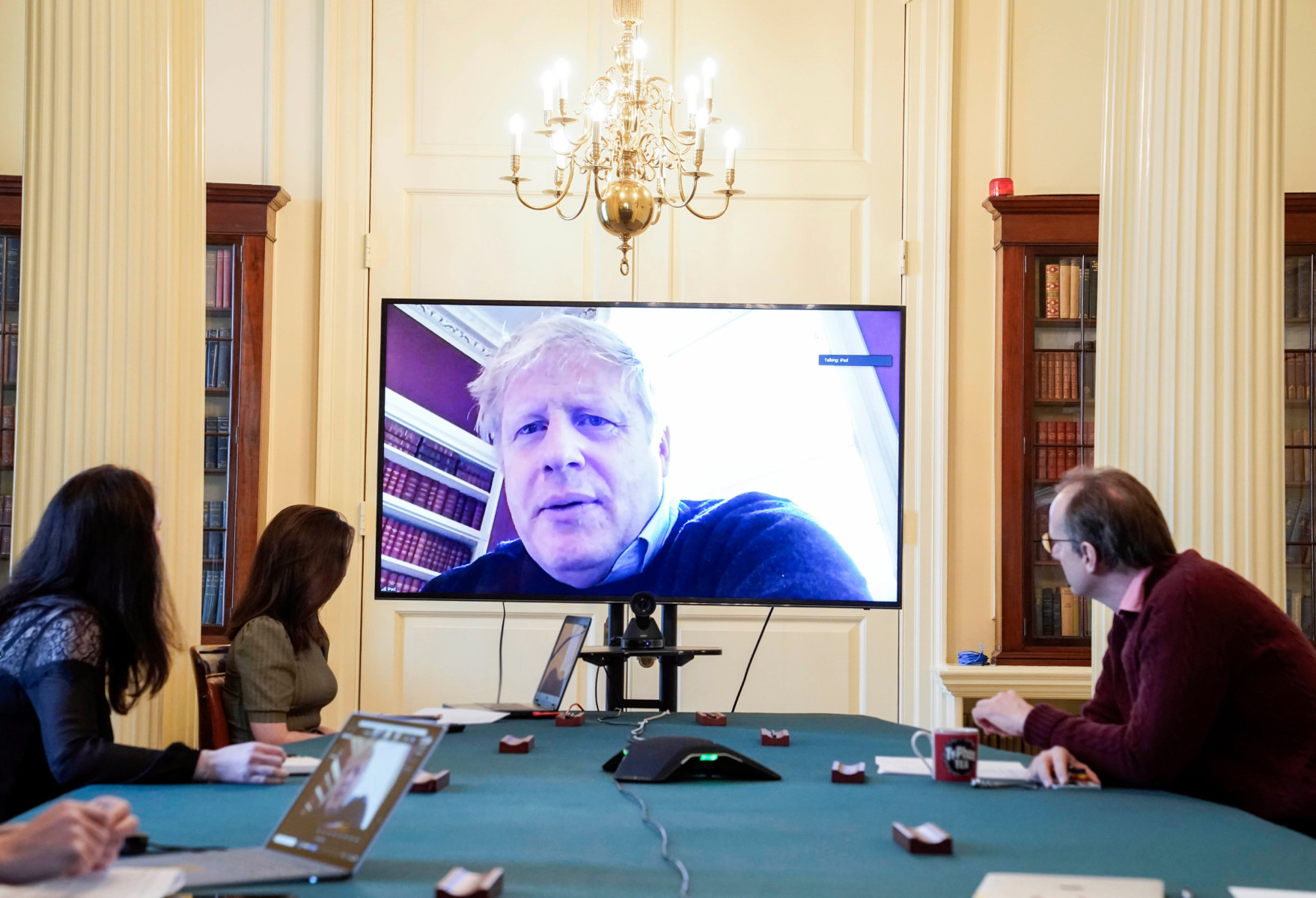 The PM is seen on screen discussing the Covid-19 situation with officials today as he self-isolates after testing positive for coronavirus