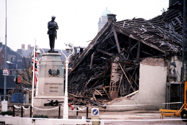 The Cenotaph at Enniskillen with the devastated community centre in the background after it was hit by an IRA bomb in 1987