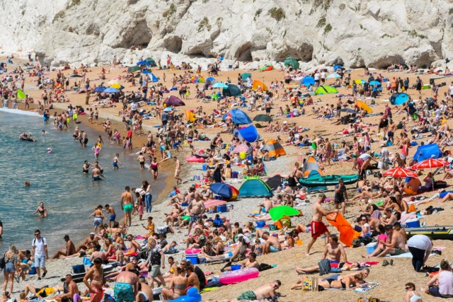 Visitors and sunbathers flock to Durdle Door at Lulworth in Dorset