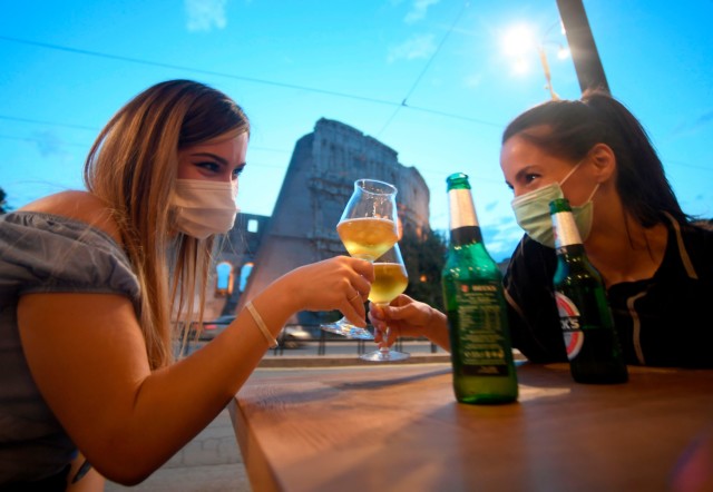 Two women have a drink outside in Italy where bar rules have been relaxed