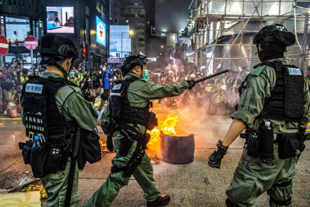 Police and pro-democracy protesters clash in Hong Kong as the city's legislature debates over a law that bans insulting China's national anthem