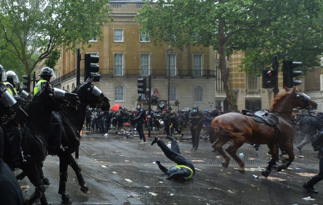 This is the moment a police officer goes flying off the back of a horse during yesterday's protests