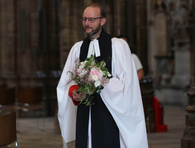 Reverend Anthony Ball holds Beatrice's bouquet inside Westminster Abbey