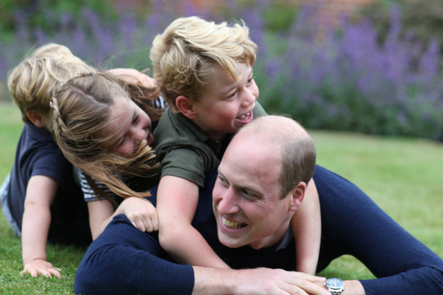 The family rolled around on the grass in a touching photo released by Kate Middleton to mark Father’s Day