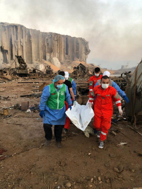 Rescue workers carry the body of one victim from near the blast's epicentre