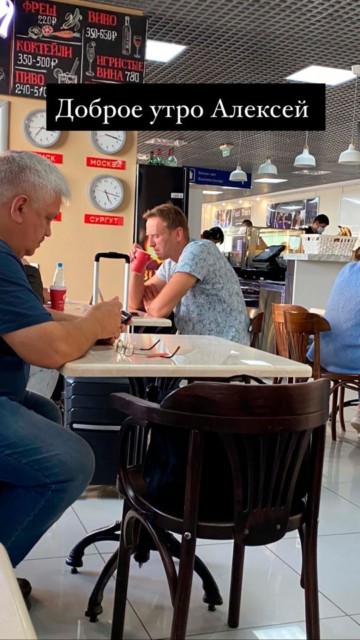 Navalny is pictured drinking tea at the airport before he became ill