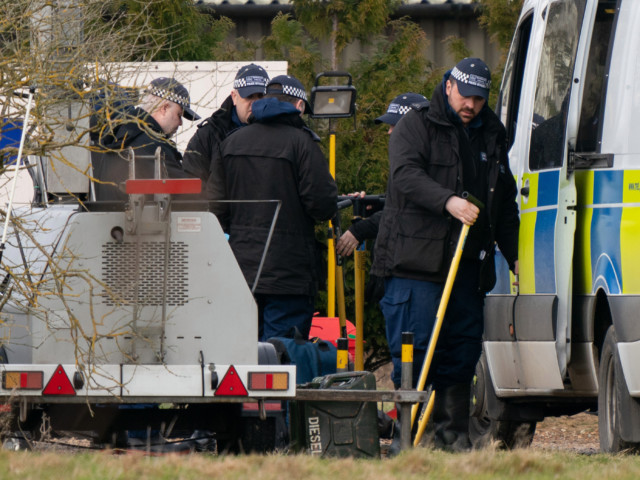 Police are seen in Ashford, Kent where human remains were found in woodlands