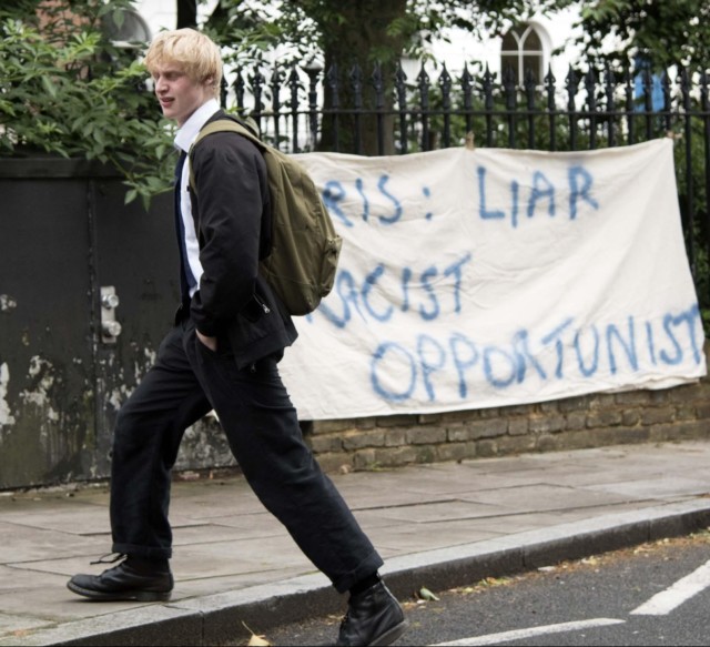 Theodore was pictured in school uniform walking past a protest by his home 
