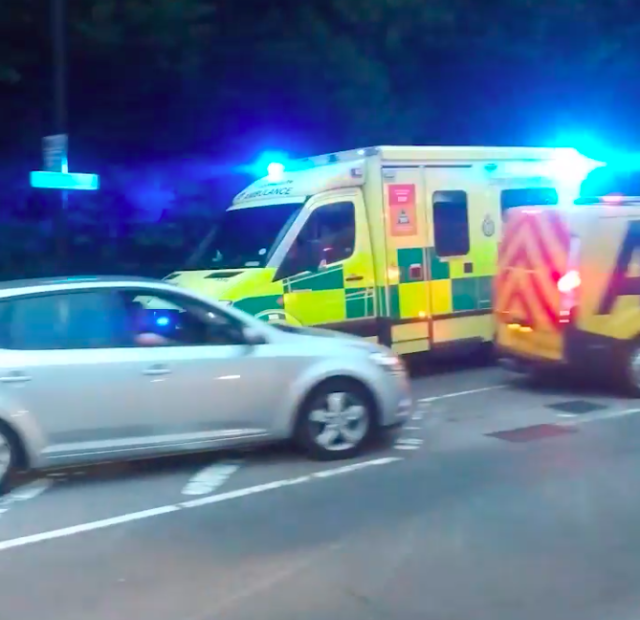 An ambulance tried to make its way past cars queueing for petrol