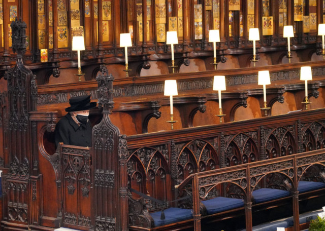 The Queen sits alone in St George's Chapel as her husband is laid to rest