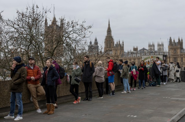 Groups of people queue in Westminster today for a Covid booster