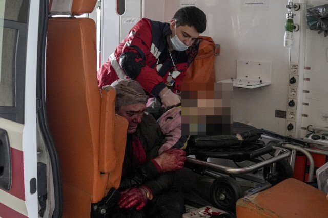 Putin's invasion of Ukraine has killed at least 16 children after forces bombed a nursery school. Pictured: Medics try to save girl, aged six, beside blood-soaked dad